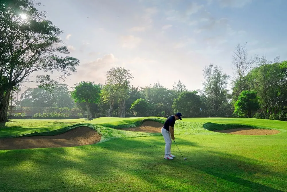 A golfer playing the tree-lined parkland fairways of Bali Beach Golf Course in Sanur, Bali — the nine-hole course closed in 2021